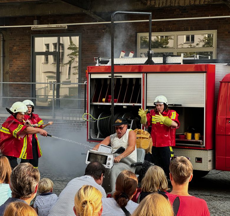 Veranstaltung im Innenhof der Konsumzentrale Leipzig, Publikum vor einem Feuerwehrfahrzeug