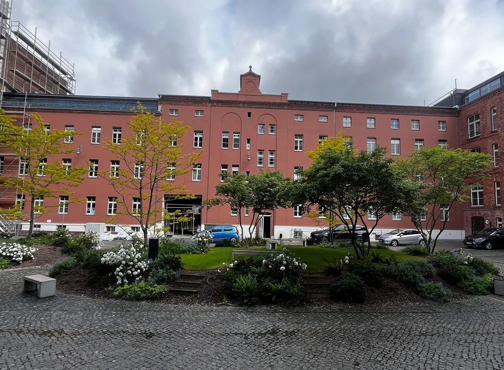 Gründerzeitfassade des Alten Kontors in Altrosa mit begrüntem Vorplatz und Kopfsteinpflaster